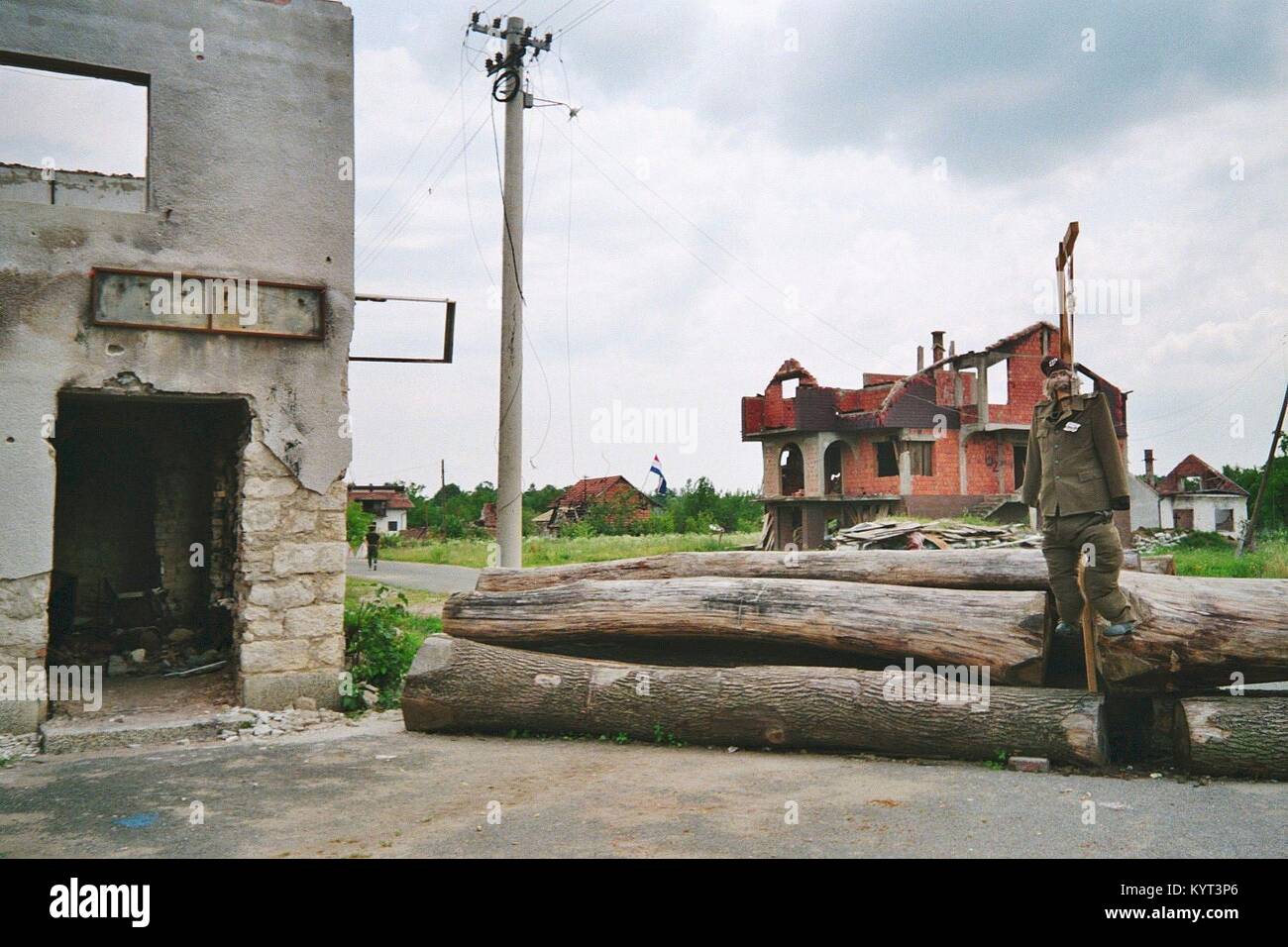 Sunja (Moslavina) en Croatie : Pendant la guerre 1991 - 1995 Le village était presque entourée de troupes serbes, et uniquement accessible par traversier de la rivière Sava. Les bâtiments détruits, des barricades de bois et un avec la poupée gallow symbolique d'un soldat serbe ('Chetnik) à la ligne de front entre la République de Croatie et la République serbe de Krajina. La photo a été prise en juin 1992. Banque D'Images