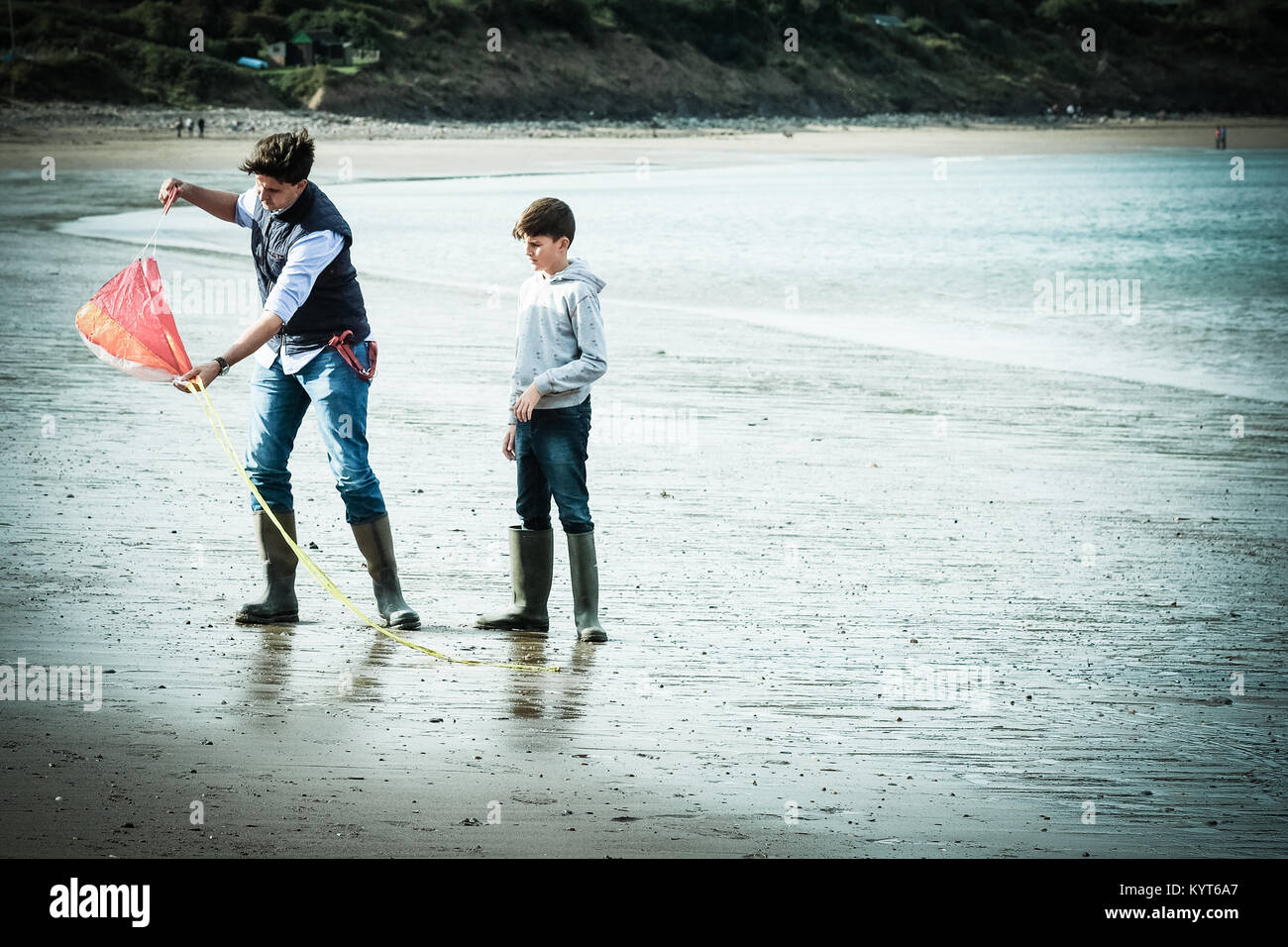 Père et fils sur la plage avec kite à Runswick Bay, Yorkshire, UK Banque D'Images