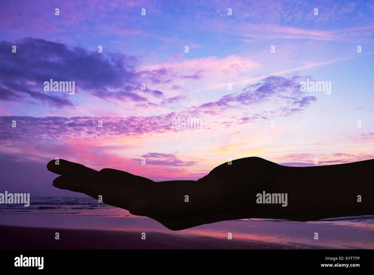 Silhouette d'une main ouverte, fond coucher de soleil Banque D'Images