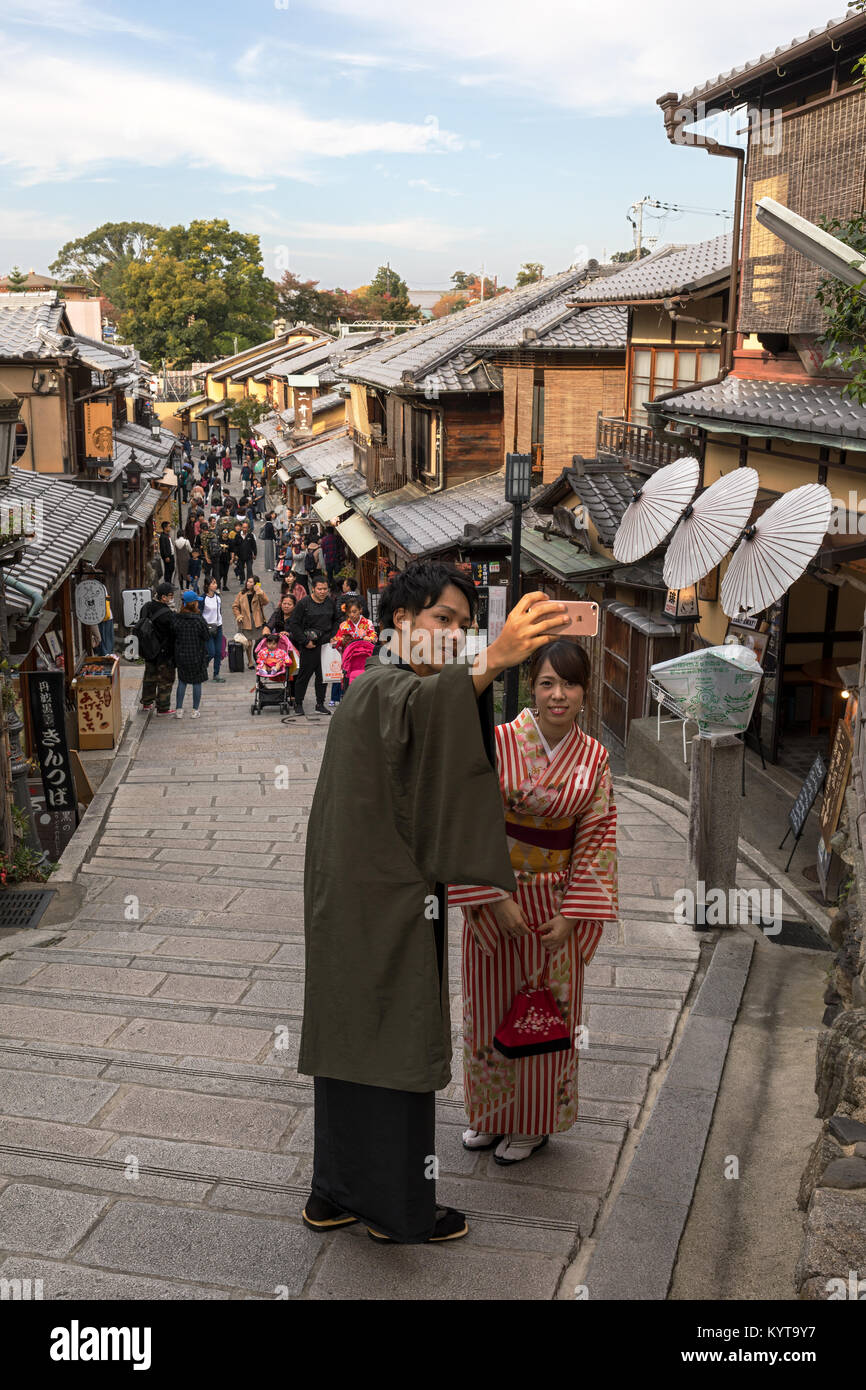 Kyoto, Japon, le 7 novembre 2017 : un couple vêtu de vêtements traditionnels japonais prendre un en selfies Ishibei-koji street dans l'est de Kyoto. Banque D'Images