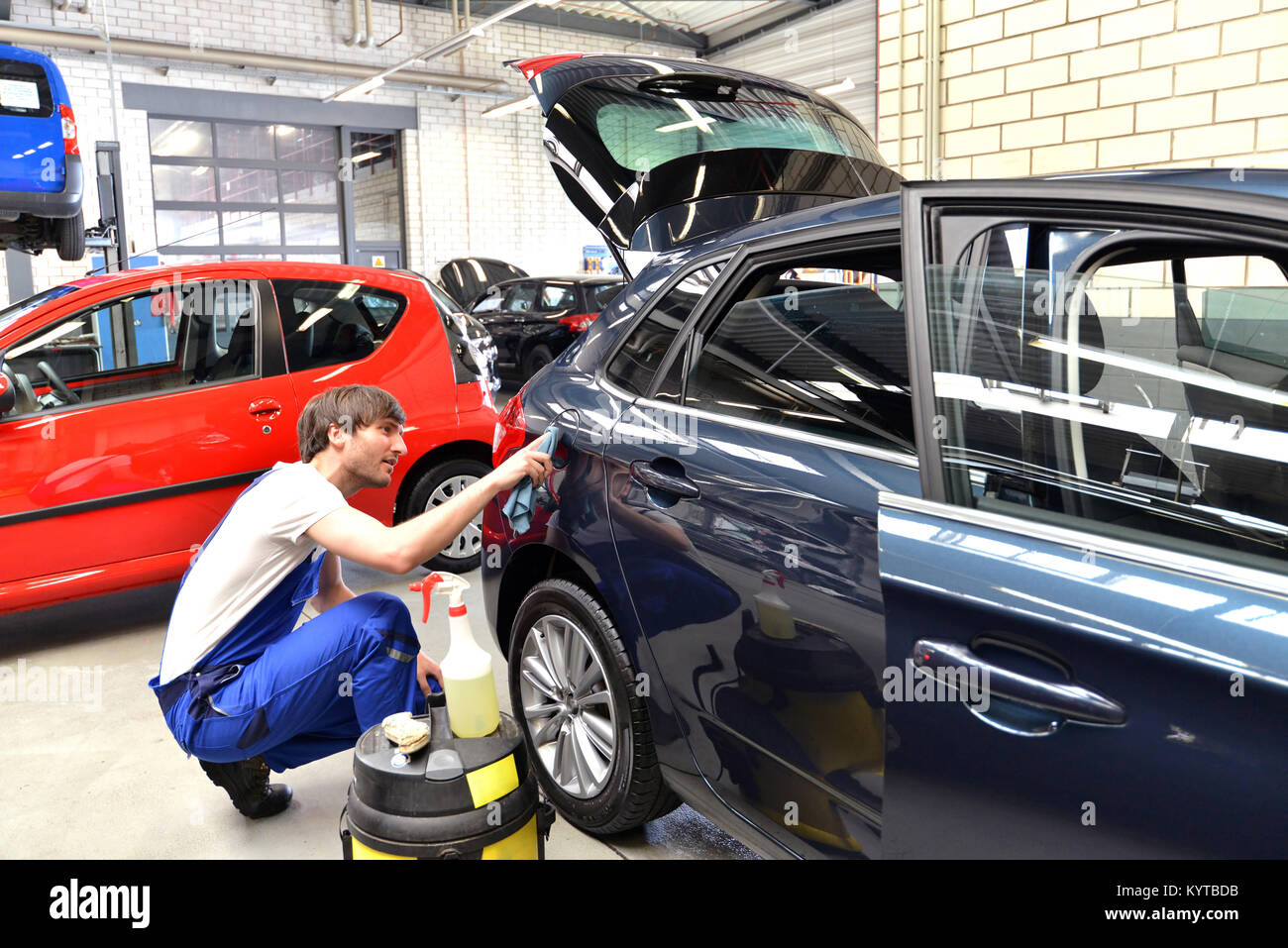 L'homme à un nettoyage de l'atelier une voiture - service pour le client Banque D'Images