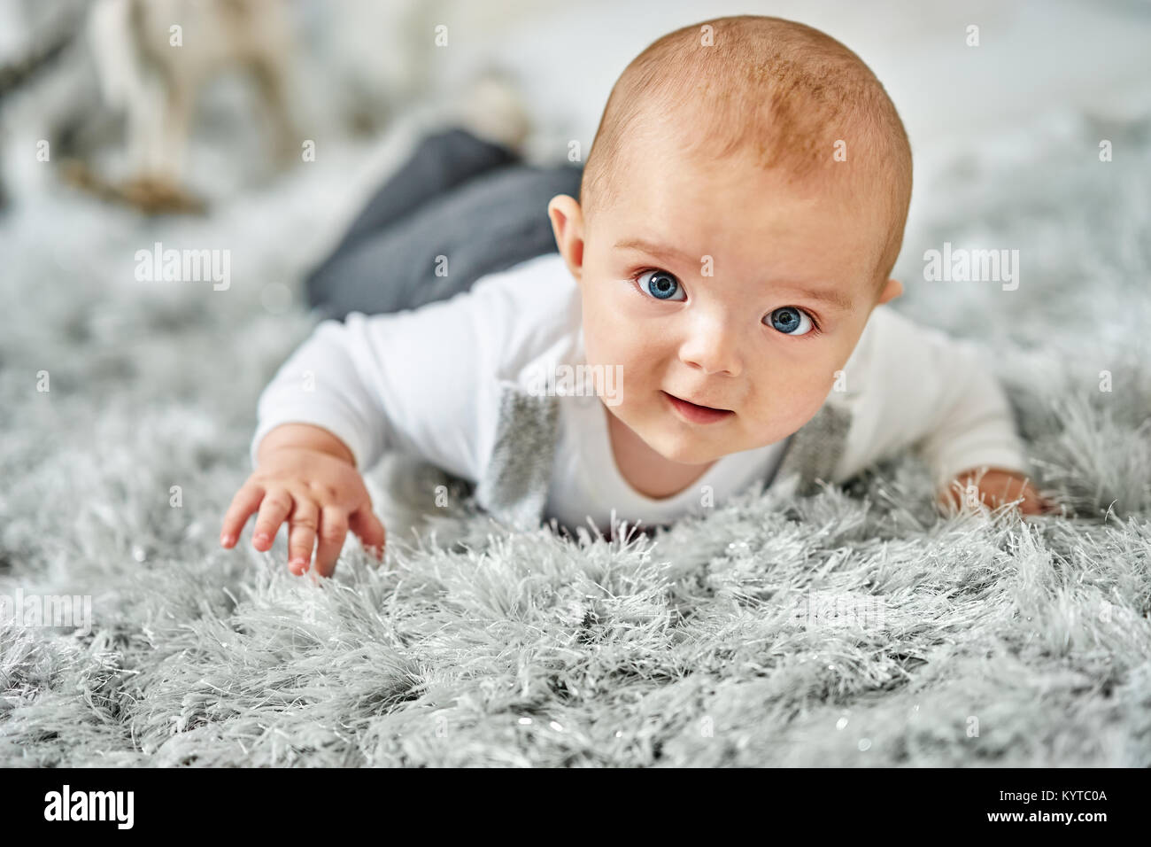 Magnifique petit garçon modèle allongé sur le ventre et à la caméra en Banque D'Images