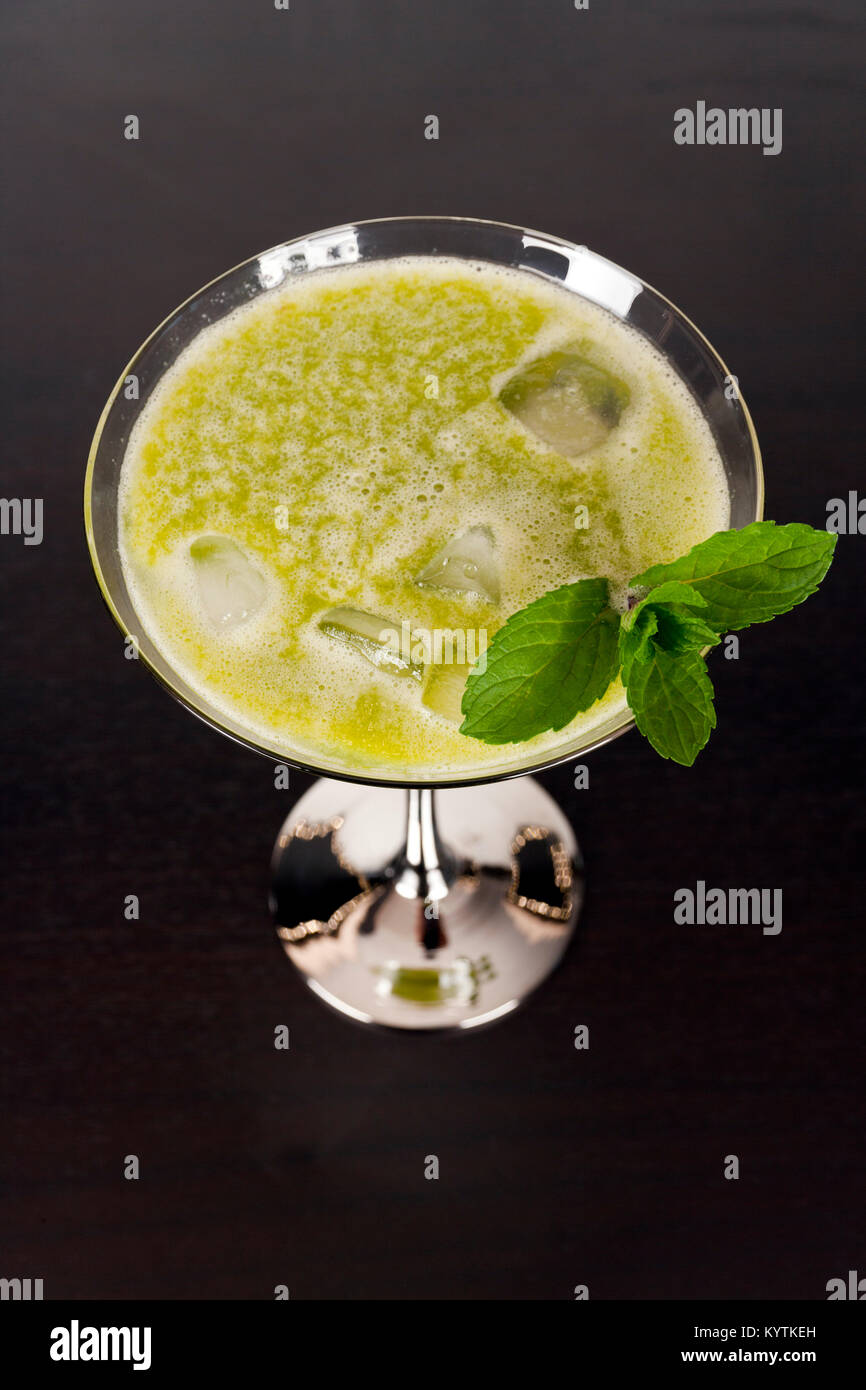 Les fruits et légumes en jus vert dans verre à cocktail avec une feuille de menthe Banque D'Images