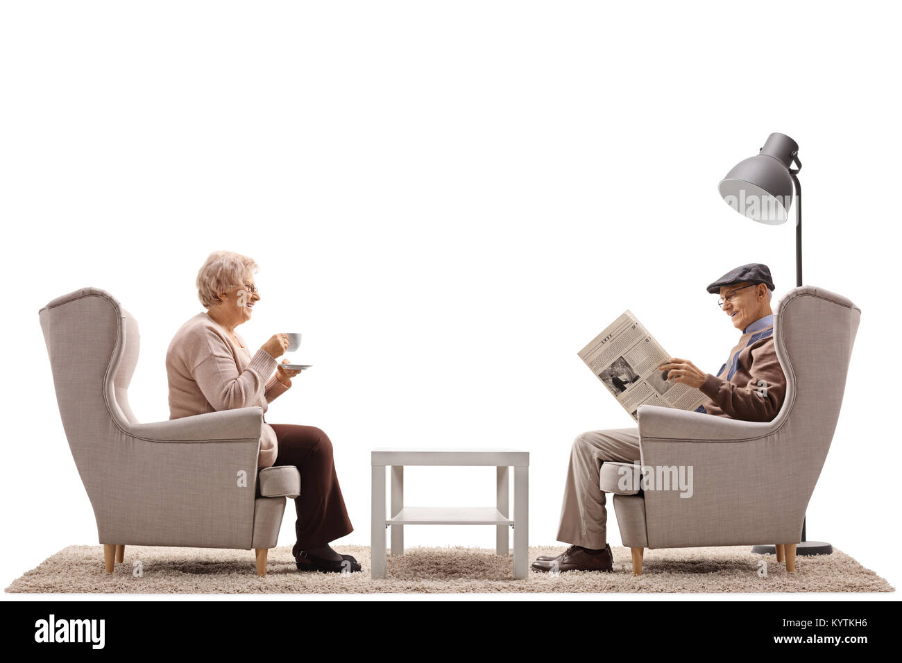 Femme âgée avec une tasse et un homme âgé lire un journal assis dans les fauteuils isolé sur fond blanc Banque D'Images