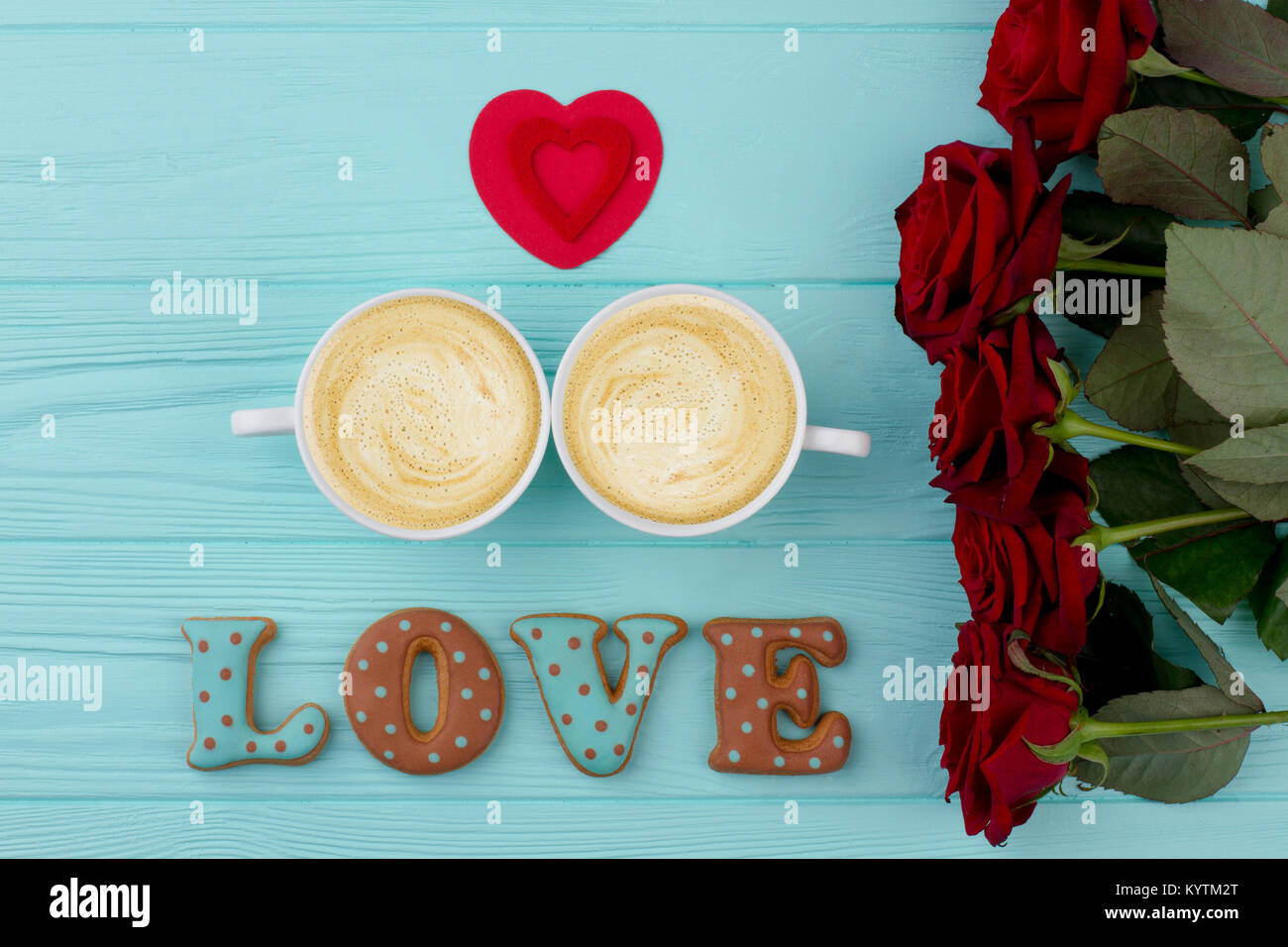 Le café et les roses, fond de bois. Mot amour de petits gâteaux, deux tasses de café. Coeur rouge et des fleurs. Célébration de la Saint Valentin. Banque D'Images