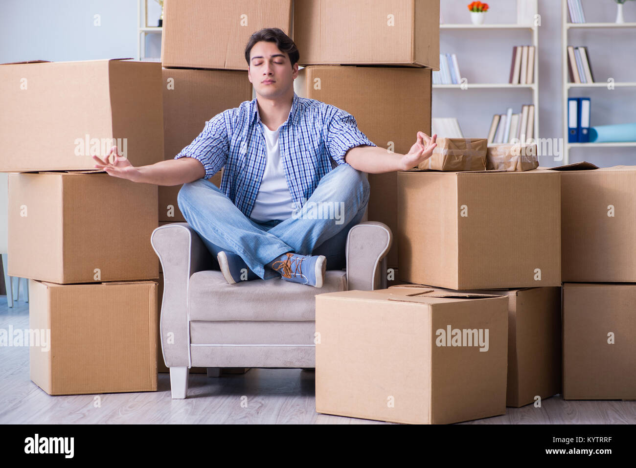 Jeune homme déménagement dans de nouvelles boîtes avec chambre Banque D'Images