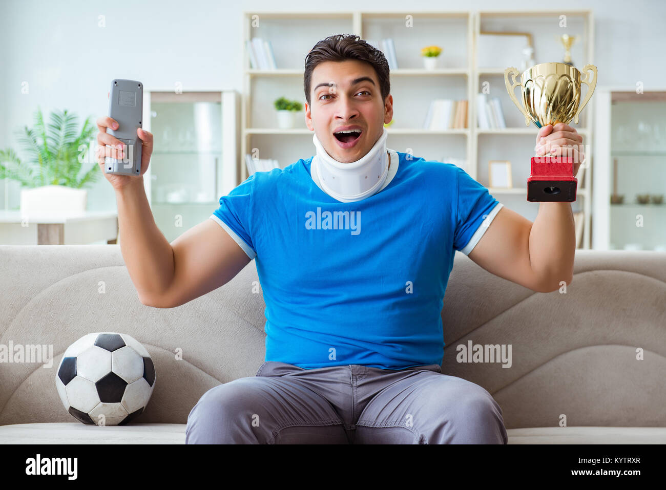 Homme avec blessure au cou à regarder à la maison football soccer Banque D'Images