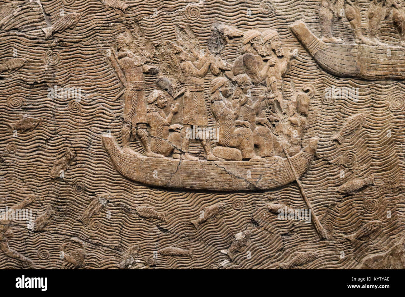 Les chiffres égyptien dans une barque entourée par les poissons - bas-relief sculpté dans la pierre - contexte Banque D'Images