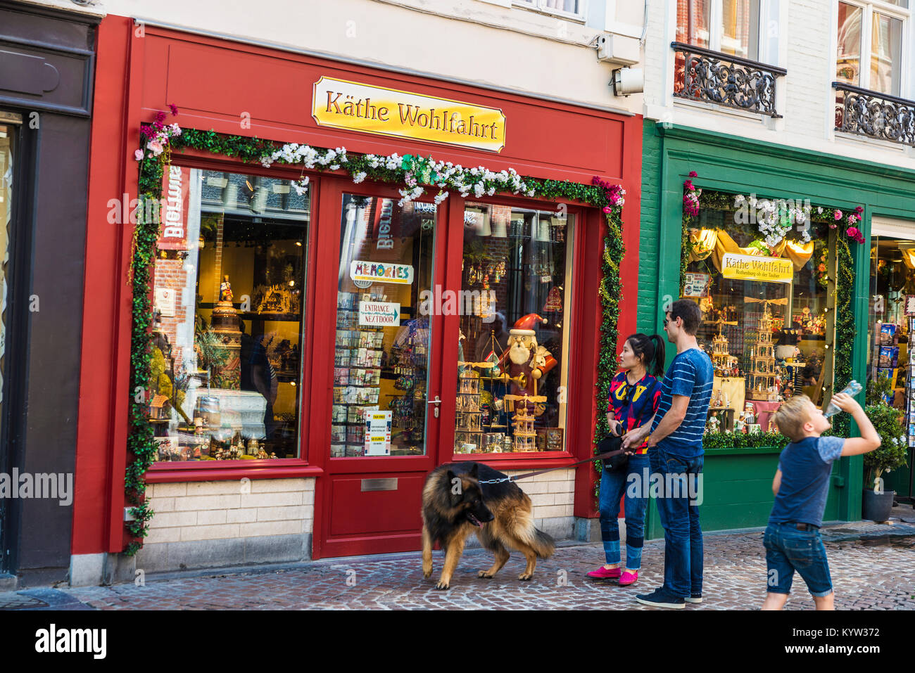 Bruges, Belgique, - 31 août 2017 : Souvenirs d'un jeune couple en train de marcher leur chien et un enfant boit l'eau dans la ville médiévale de Bruges, Belgique Banque D'Images