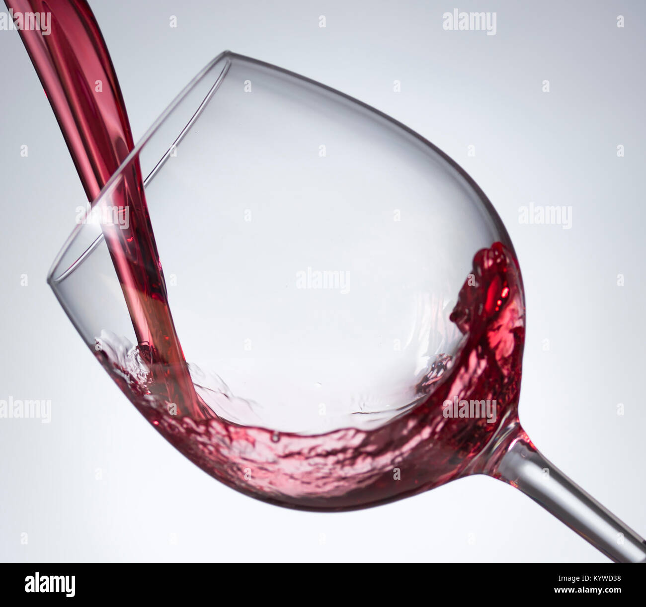 Verseur à vin rouge en verre avec fond blanc gris Banque D'Images