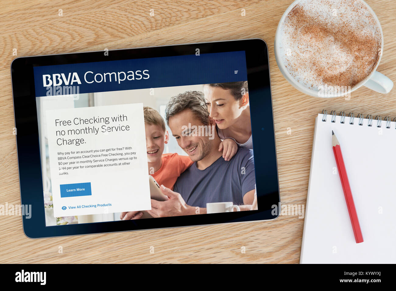 BBVA Compass le site internet sur une tablette iPad, sur une table en bois à côté d'un bloc-notes, crayon et tasse de café (rédaction uniquement) Banque D'Images