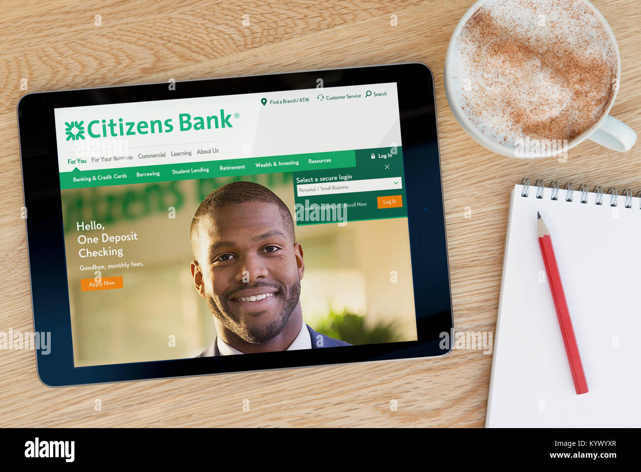 La Citizens Bank Site internet sur une tablette iPad, sur une table en bois à côté d'un bloc-notes, crayon et tasse de café (rédaction uniquement) Banque D'Images