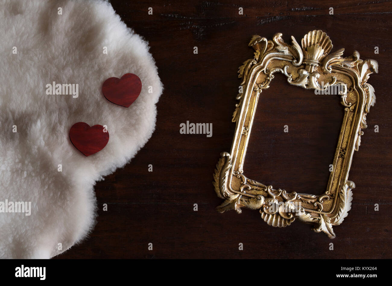 Or antiq photo frame dans un style rococo, sur fond de bois rustique foncé avec du blanc mouton de Toscane et les cœurs Banque D'Images
