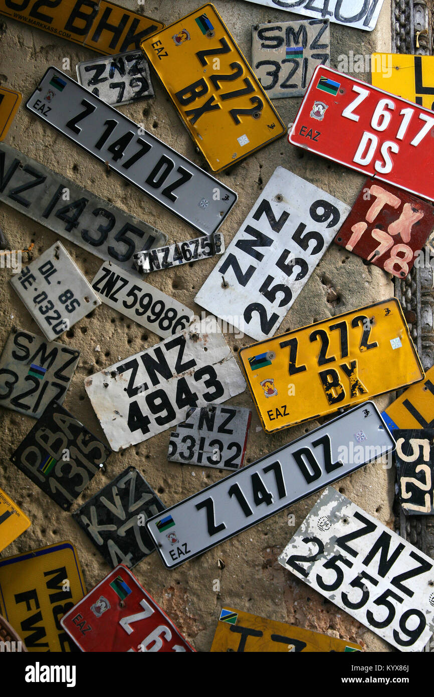 Des plaques minéralogiques sur mur dans la boutique Obama, Stone Town, Zanzibar, Tanzanie. Banque D'Images