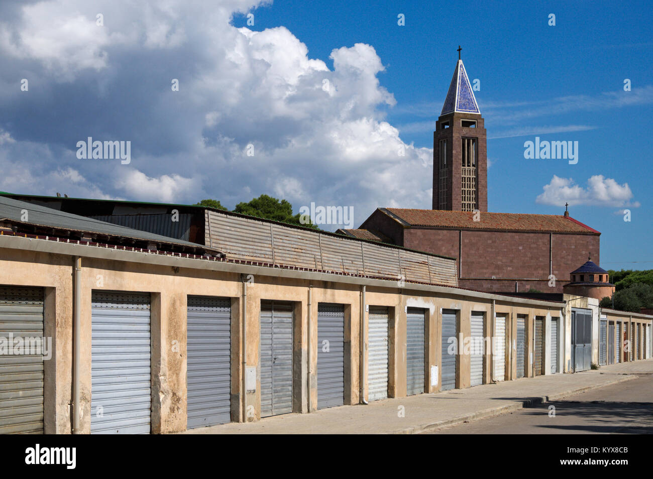 Garages dans une rangée et Eglise de San Marco à Fertilia, près de Alghero, Sardaigne, Italie Banque D'Images