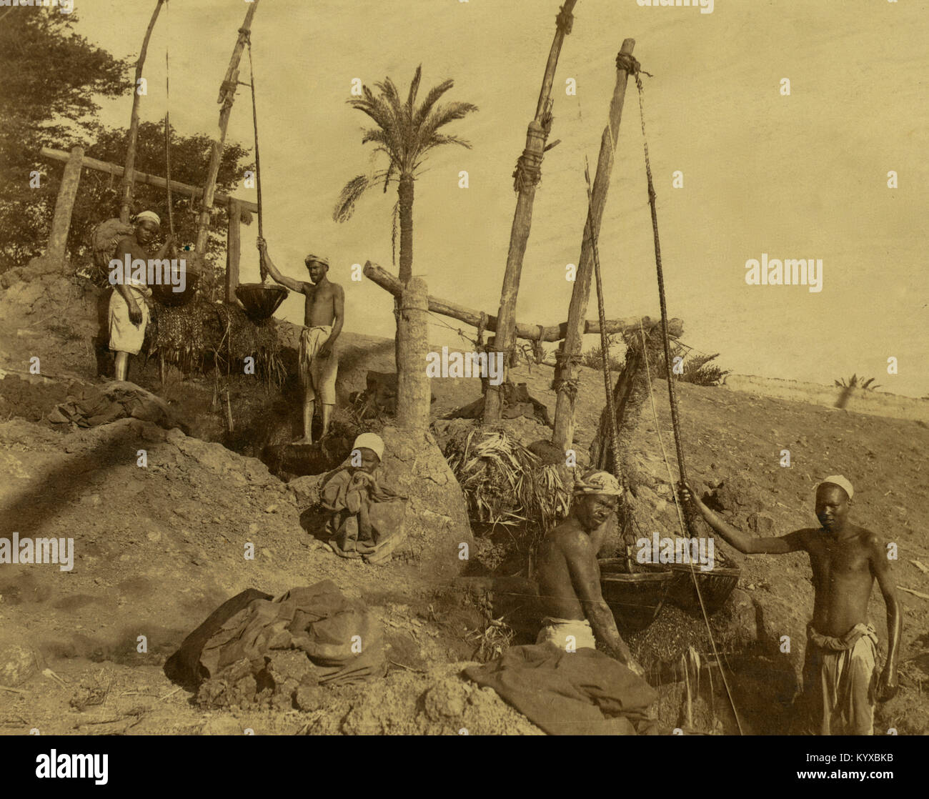 Hommes debout à côté d'une série d'shadoofs shadufs (dispositifs de levage), dont l'eau d'un ruisseau ou bien pour l'irrigation. Banque D'Images