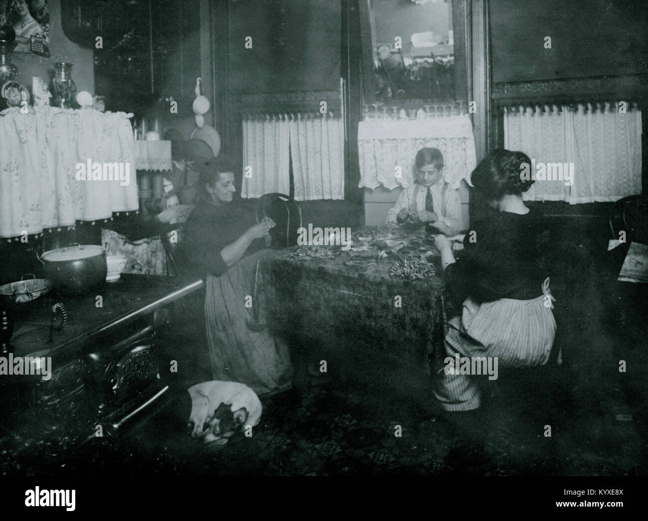 Mme Barattini, Janitress et fils Louis, 14 ans, et sa fille qui travaille dans une usine de fleurs tous les jours et aide sa mère faire ces pétales de rose en soie dans la nuit. Banque D'Images