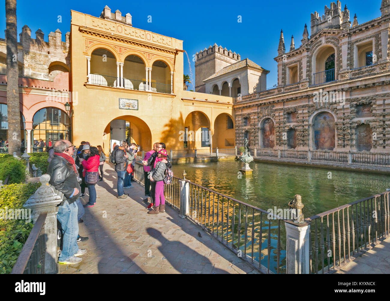 ALCAZAR SÉVILLE ESPAGNE DÉBUT DE LA LUMIÈRE DU SOLEIL DU MATIN ET LES TOURISTES d'admirer LA PISCINE DE MERCURE LE MESSAGER DIEU Banque D'Images