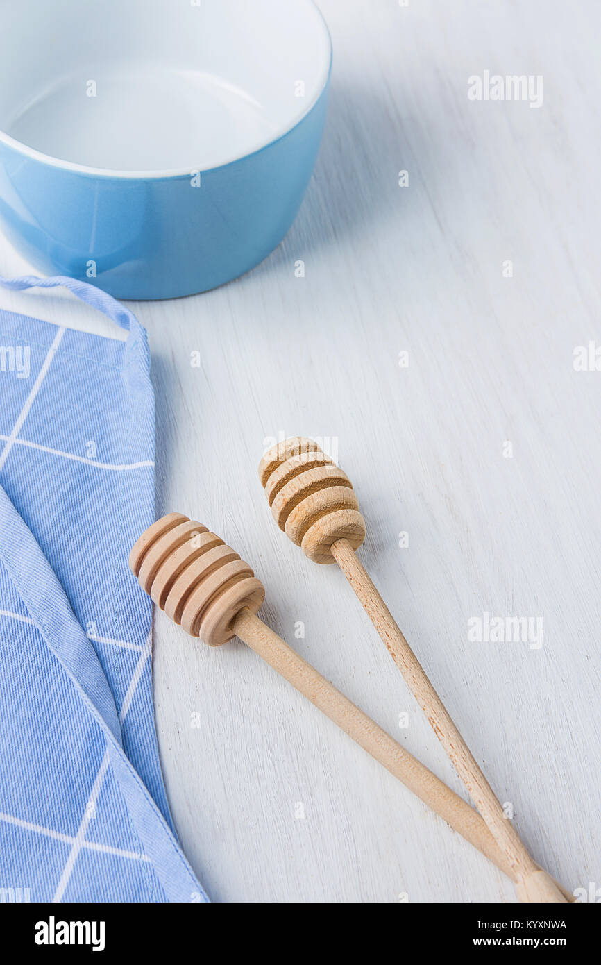 Bol Vide bleu miel en bois cuillères balanciers Tablier de coton blanc sur table. Concept de cuisine pâtisseries de Noël. Noël Pâques. Provence scandinave Kitch Banque D'Images