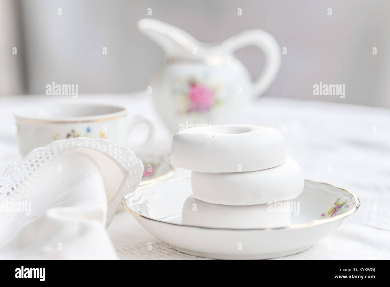 Bateau à thé en porcelaine sur nappe blanche à glaçure blanche avec des bagels sur une plaque Banque D'Images