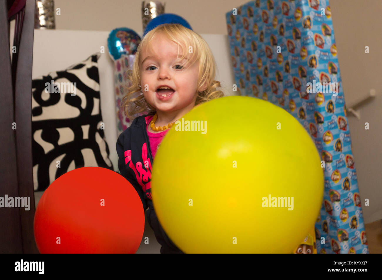 Happy 2 year old girl with balloons Banque D'Images
