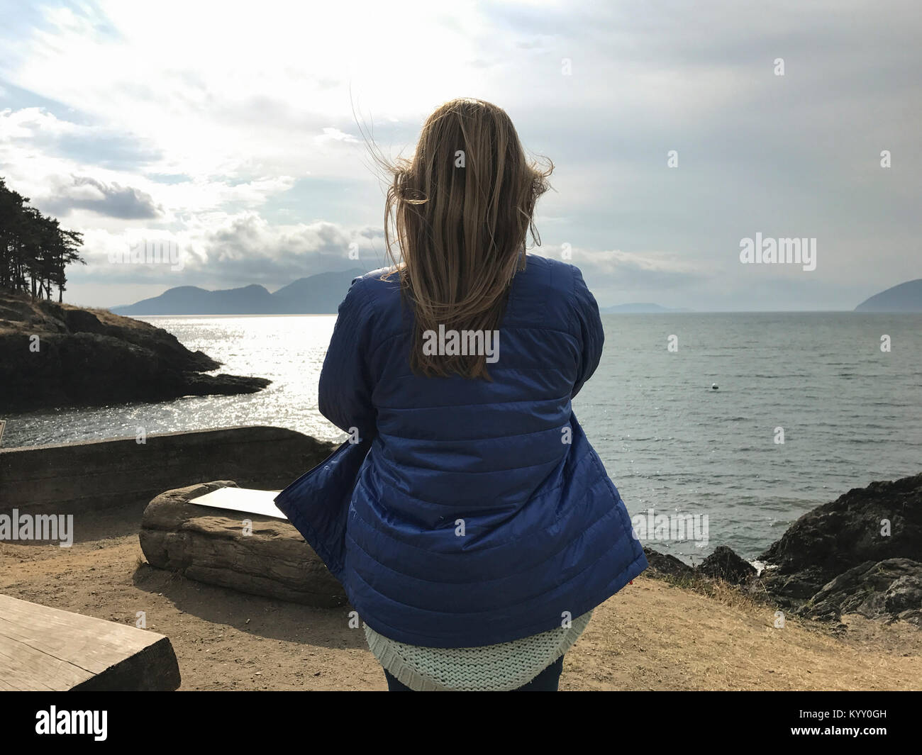 Woman wearing jacket while looking at view by river Banque D'Images