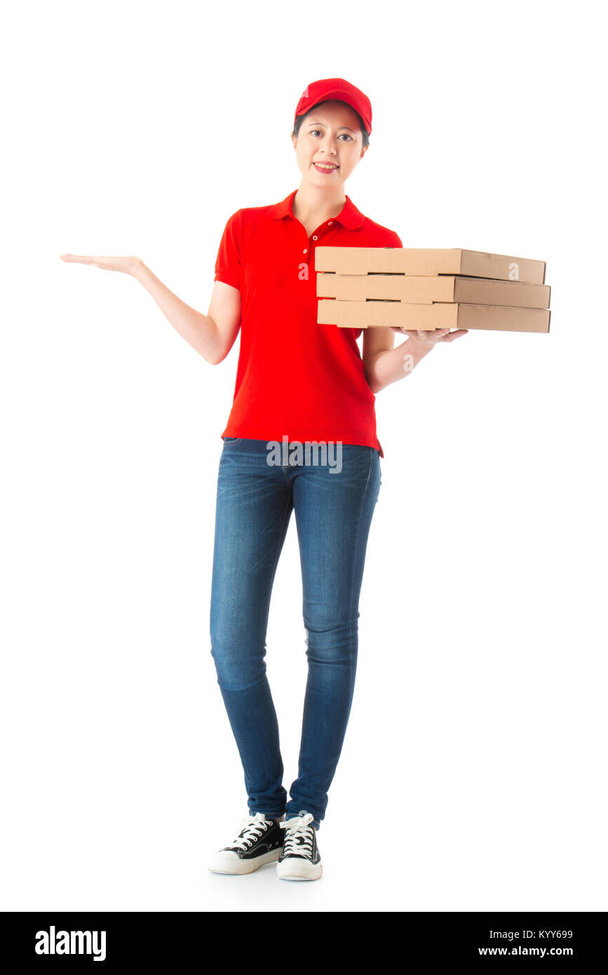 Jolie femme élégante de livraison de pizza le fonctionnaire ayant un box debout en fond blanc et à la caméra à faire de geste présentant toute la longueur phot. Banque D'Images