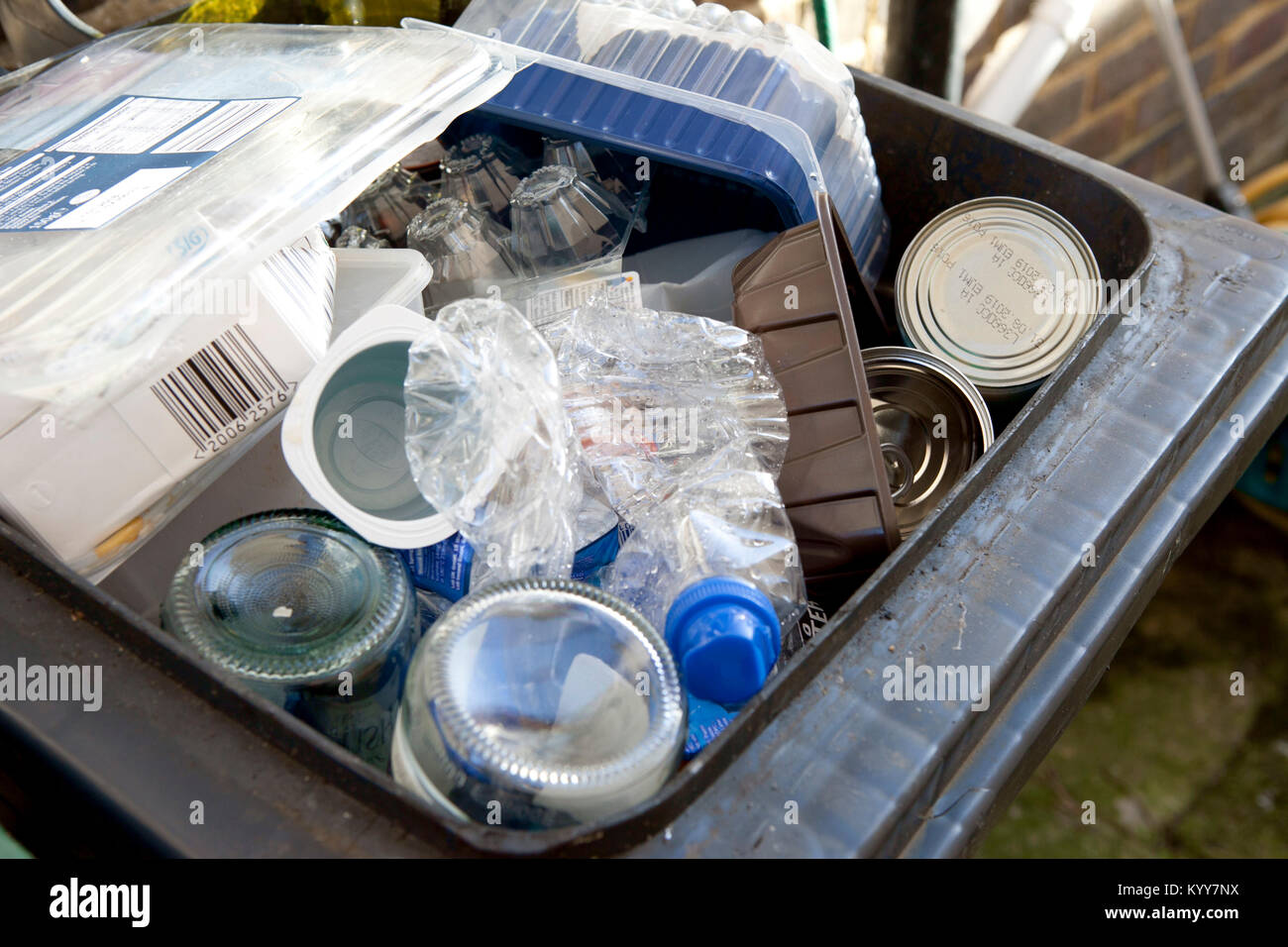 Wheelie bin plein de recyclage des déchets domestiques, des bouteilles en verre, boîtes de conserve et de bouteilles en plastique, déchets de plastique, le recyclage. Banque D'Images