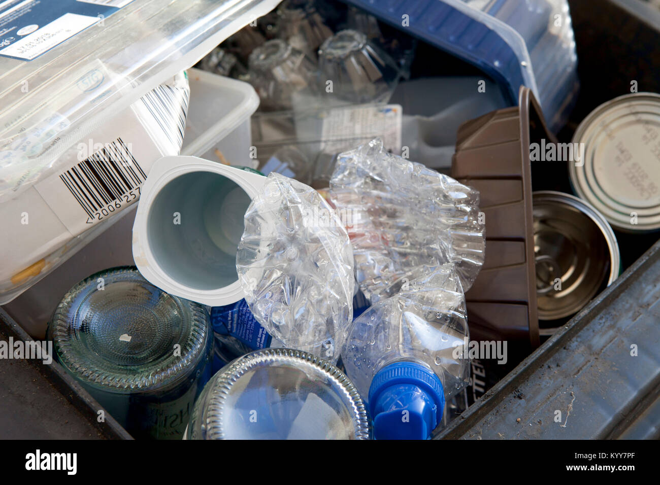 Wheelie bin plein de recyclage des déchets domestiques, des bouteilles en verre, boîtes de conserve et de bouteilles en plastique, déchets de plastique, le recyclage. Banque D'Images