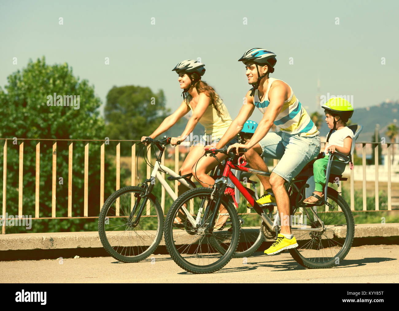 Jeune famille de quatre personnes avec des vélos dans les sports de plein air casques Banque D'Images