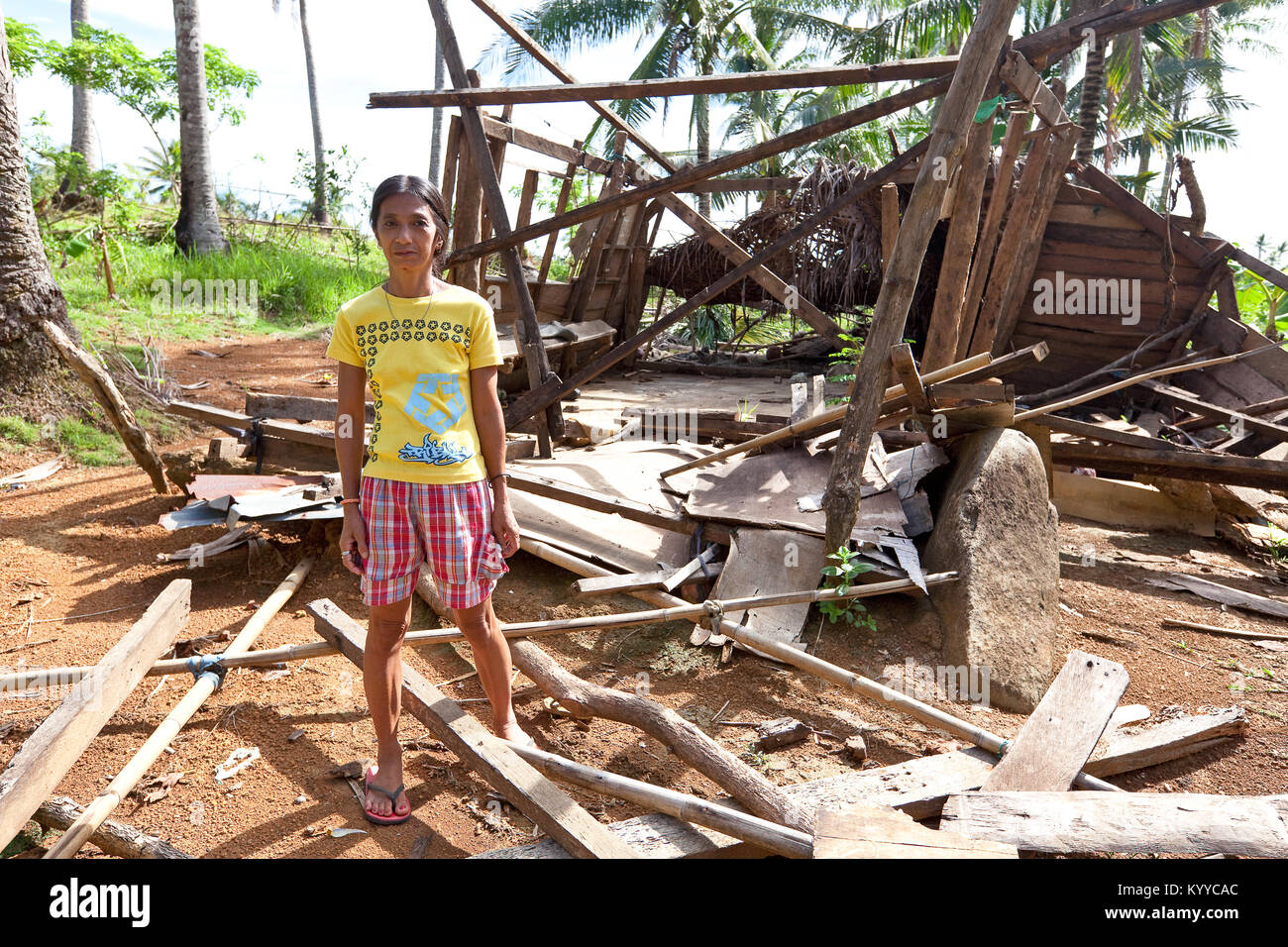 Dame se place en avant du reste de sa maison, détruite par le typhon Glenda, en milieu rural, Banquerohan Albay, Philippines. Banque D'Images