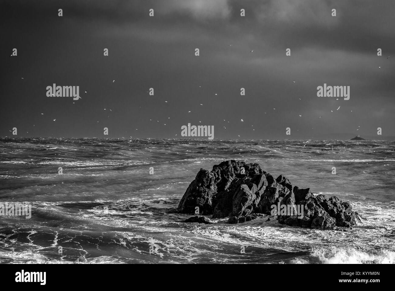 St Ives, Cornwall, UK, 16/01/2018. Mouettes troupeau derrière cette formation rocheuse comme force de coup de vent la houle de l'avant. Banque D'Images