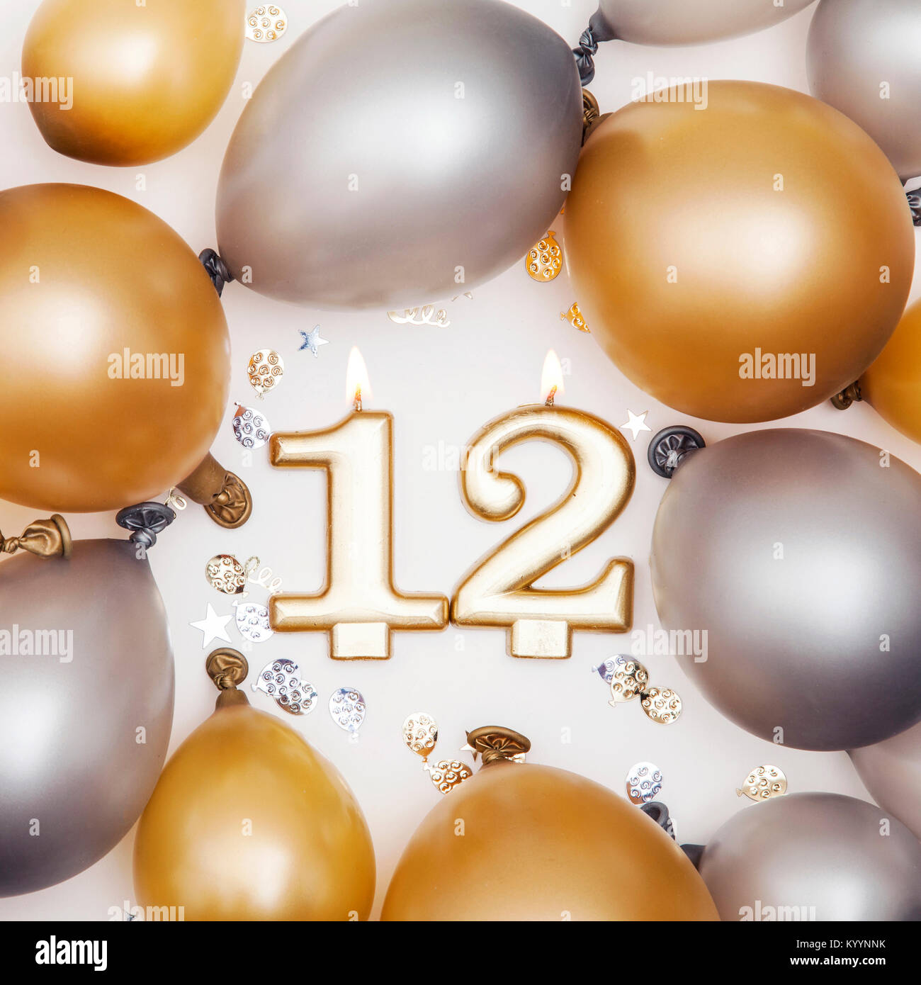 Anniversaire numéro 12 bougie avec des ballons d'or et d'argent Banque D'Images