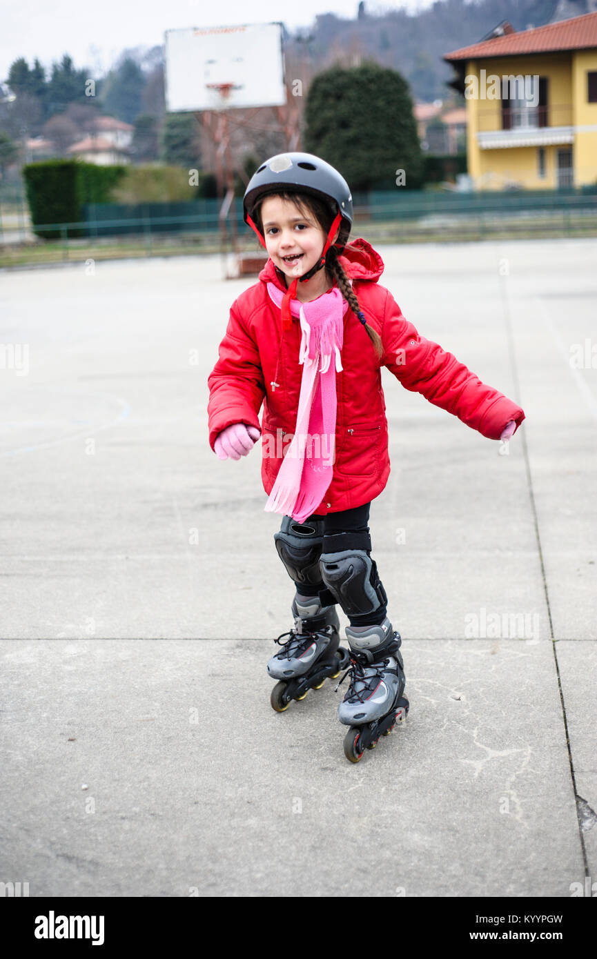 Petite fille apprend à patiner avec des patins à roues alignées à la cour  de basket-ball sur un jour d'hiver Photo Stock - Alamy