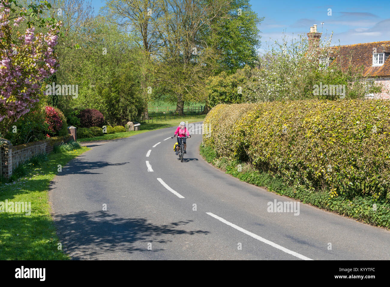 Cycliste féminine du vélo dans le village de Witchampton East Dorset Uk Banque D'Images