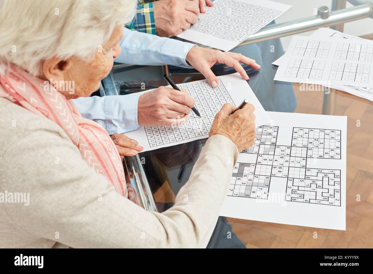 Vieille Femme résout les sudoku comme formation de mémoire contre la démence à la maison Banque D'Images