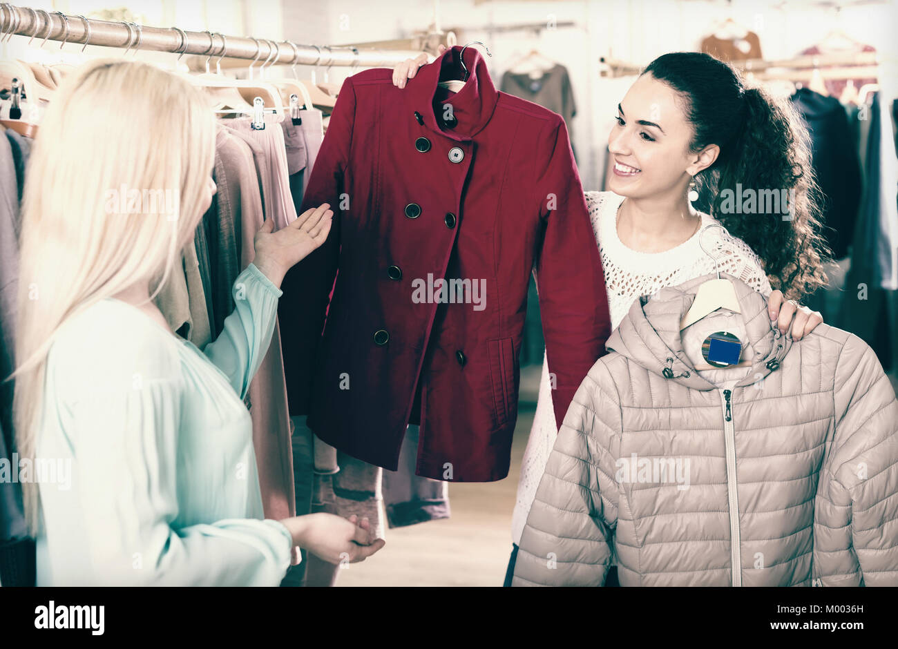 Jolie petite amie choisir veste chaude dans shopping centre and smiling Banque D'Images