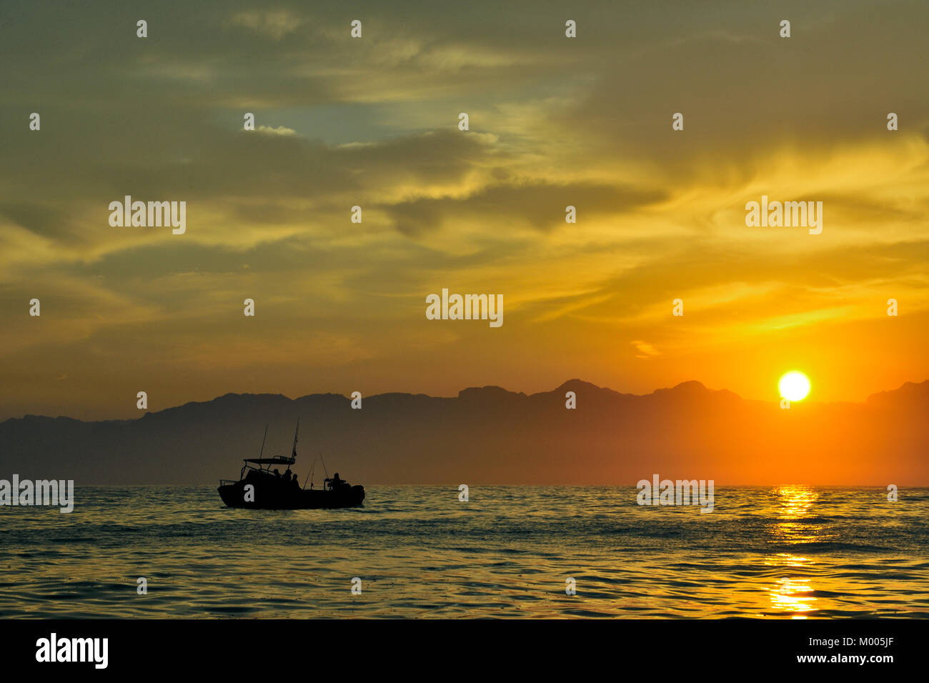 Bateau de pêche d'ossature dans la mer au lever du soleil. Tôt le matin, lever du soleil, l'océan et les montagnes. L'Afrique du Sud Banque D'Images