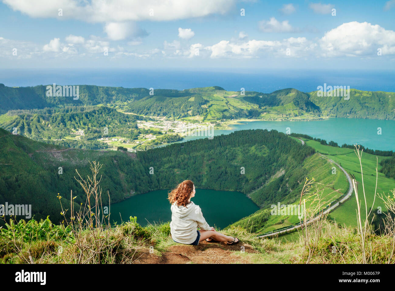 Jeune femme de randonnée appréciant la vue imprenable sur les lacs Sete Cidades depuis le point de vue de Miradouro Boca do Inferno, Sao Miguel, Açores, Portugal Banque D'Images