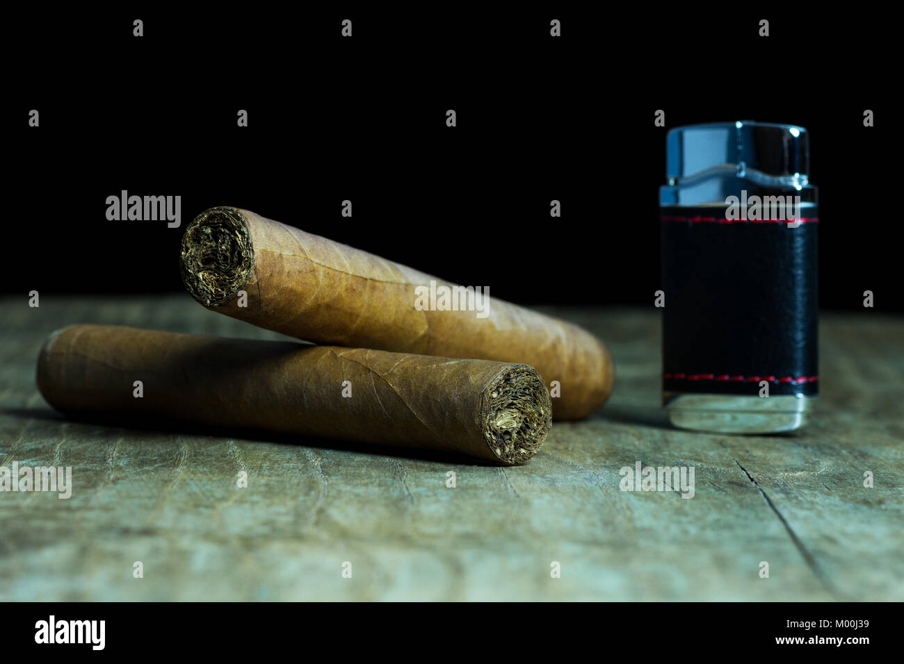 Deux cigares cubains avec un briquet sur une vieille table en bois Banque D'Images