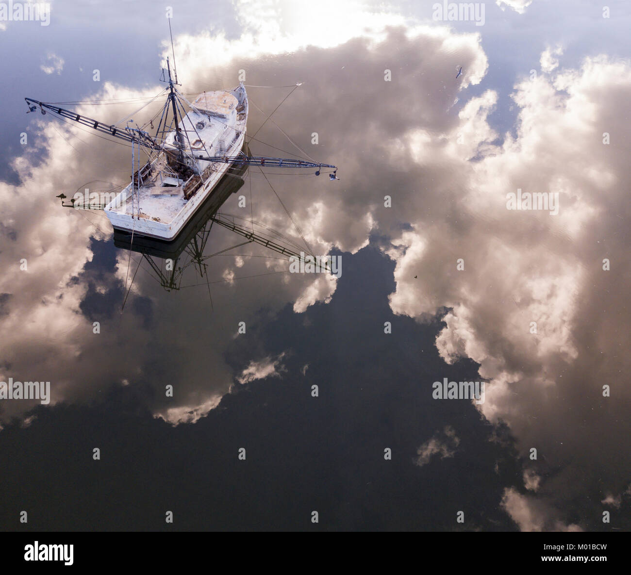 Vue aérienne de bateau de pêche en Caroline du Sud avec parfait reflet du ciel et nuages dans l'eau. Banque D'Images