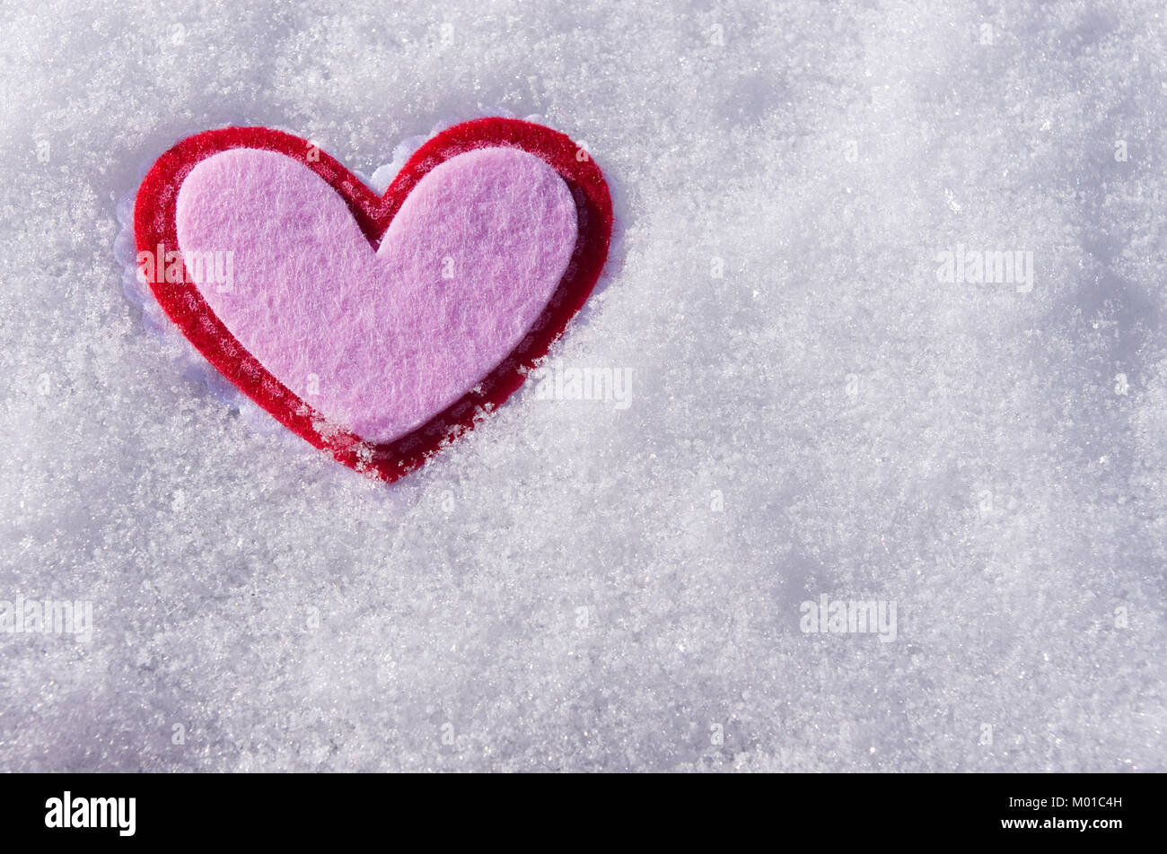 Feutre rose coeur dans la neige Banque D'Images