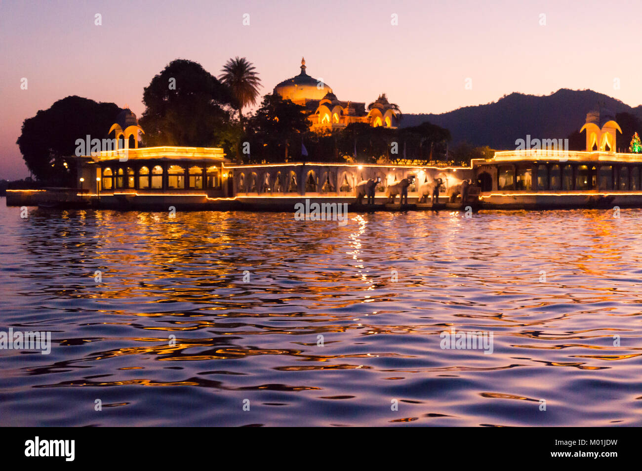 Jag Mandir lake palace sur le lac Pichola artifical tourné dans la nuit avec l'allumage des feux. La belle lumière dorée et la réflexion de la lumière mettre en valeur la belle architecture de l'île Banque D'Images