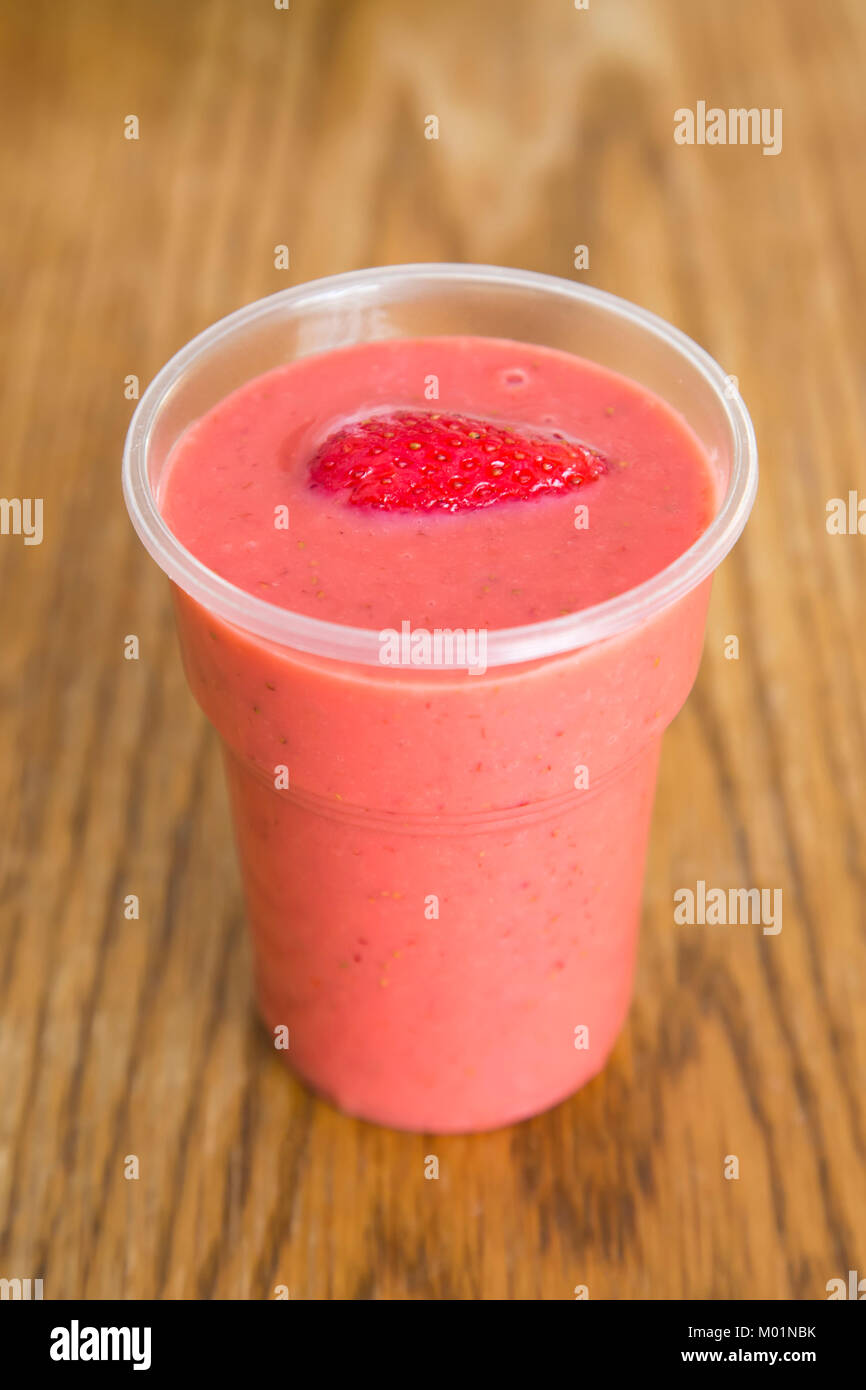 Smoothie aux fraises avec fraises entières dans une tasse en plastique Banque D'Images