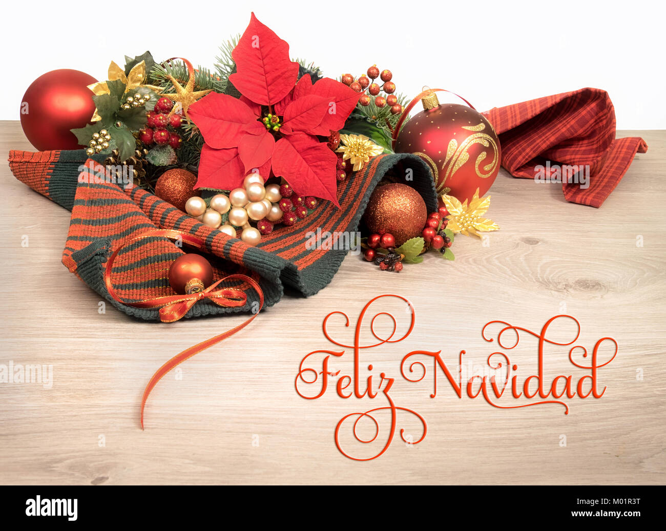 Fond de bois avec poinsettia et arbre de Noël décoré de brindilles, de texte sur l'image signifie 'Merry Christmas' en espagnol Banque D'Images