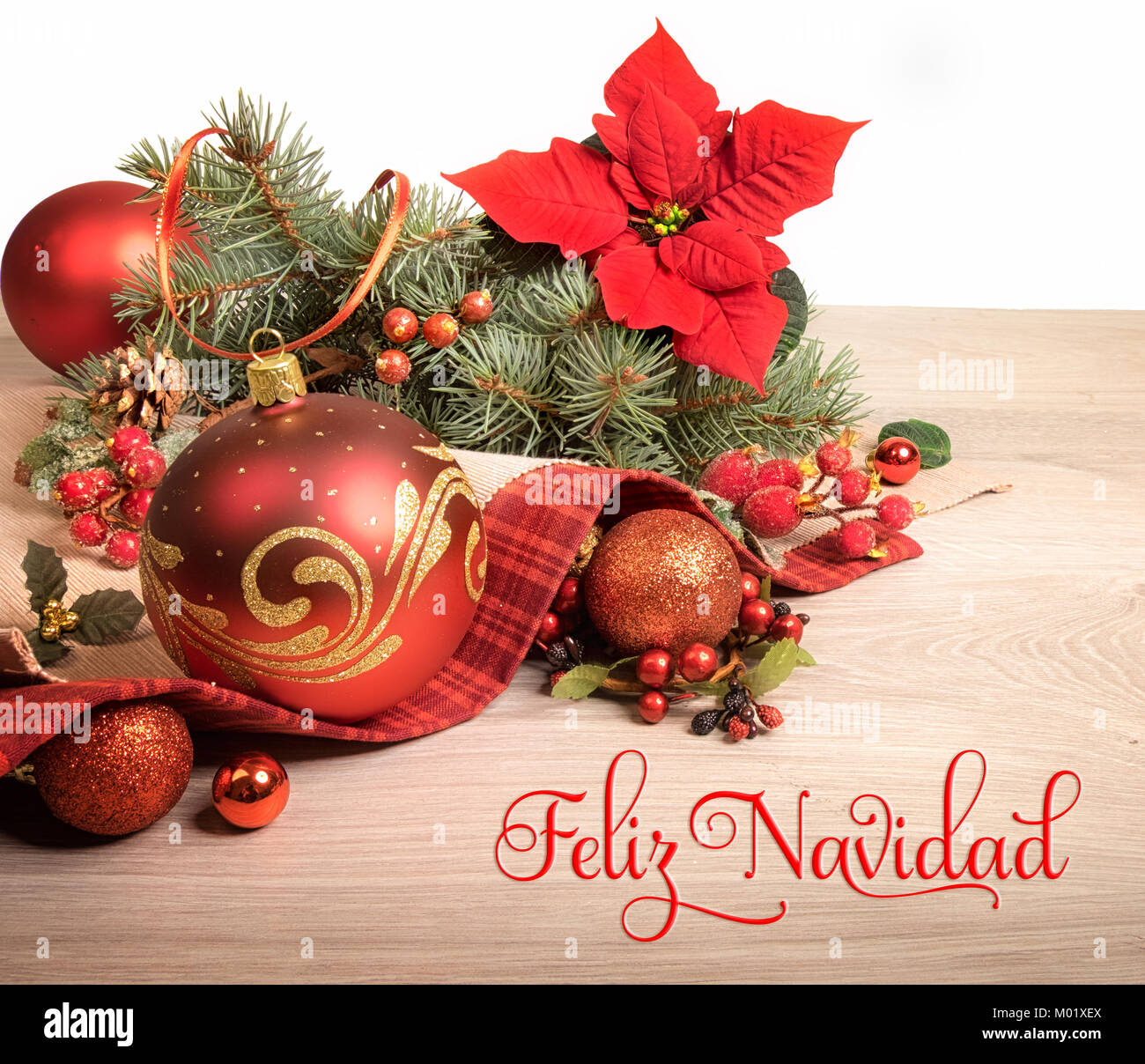 Fond de bois avec poinsettia et arbre de Noël décoré de brindilles, de texte sur l'image signifie 'Merry Christmas' en espagnol. Banque D'Images