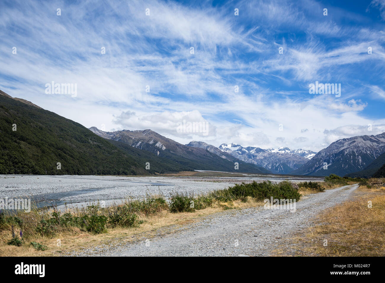 La vallée de la rivière Waimakariri glaciaire est remplie d'un lit de rivière de gravier et la tresse de rivière du même nom. Un chemin de terre longe la rivière en Banque D'Images