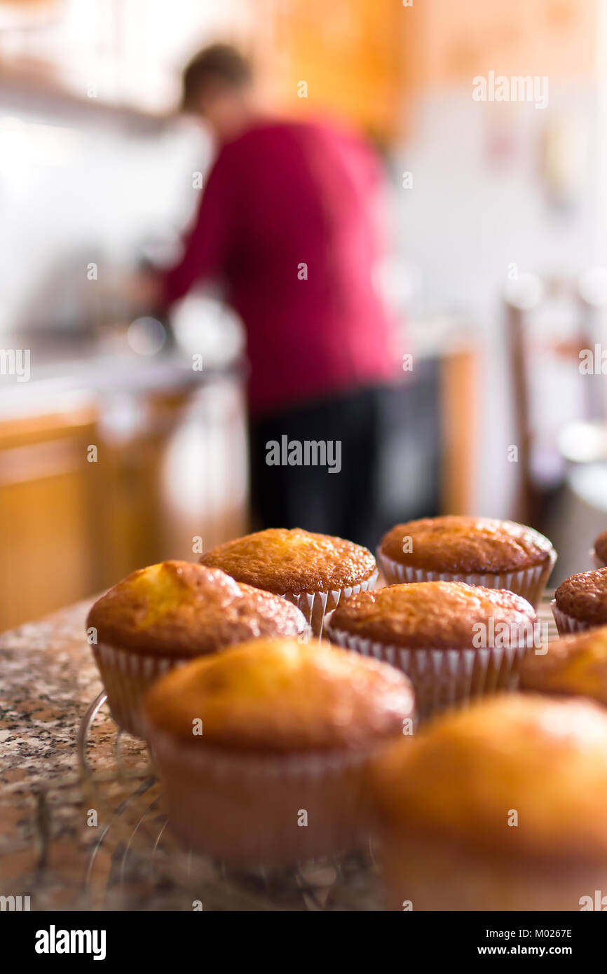 Lot de petits gâteaux faits maison ou des muffins fraîchement cuits sur une grille de refroidissement dans la cuisine dans une vue en gros plan avec focus sélectif. Flou flou artistique ba Banque D'Images