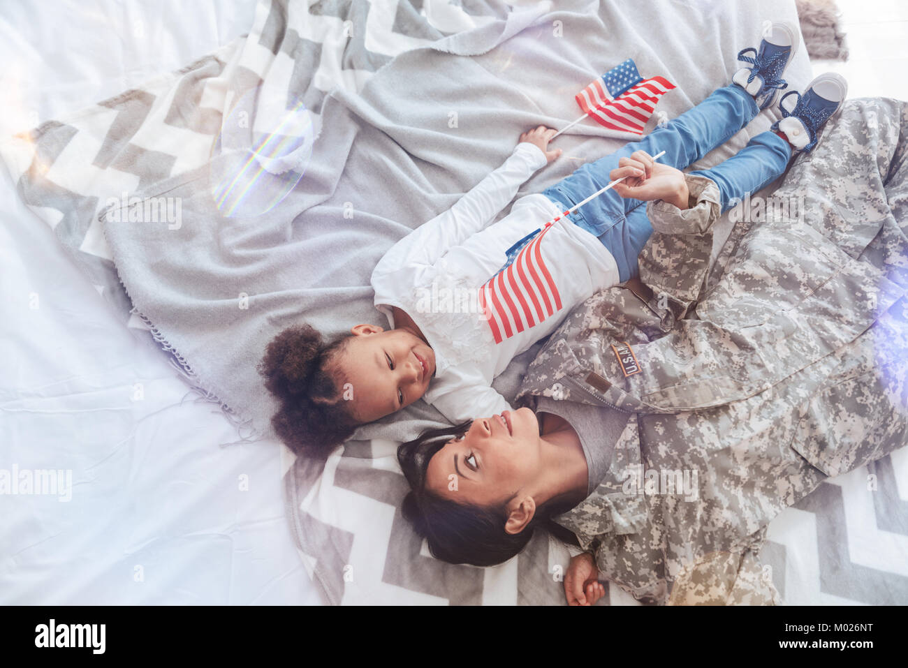 Belle femme positive avec sa fille couchée sur le lit Banque D'Images