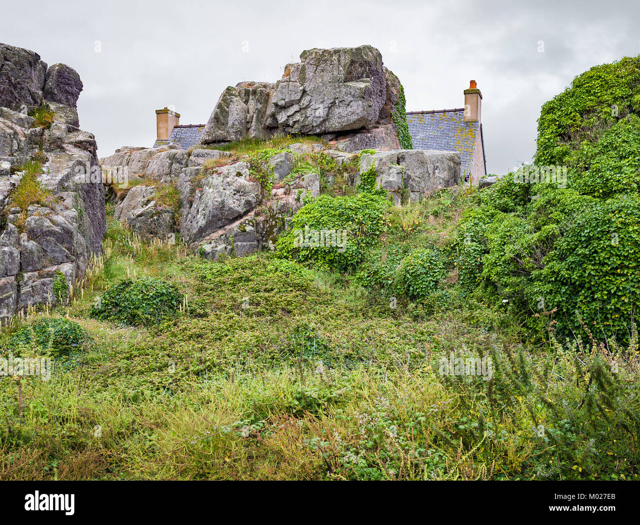 Voyage en France - maison bretonne en pierre de roche et à Plougrescant ville des Côtes-d'Armor en Bretagne au jour d'été pluvieux Banque D'Images